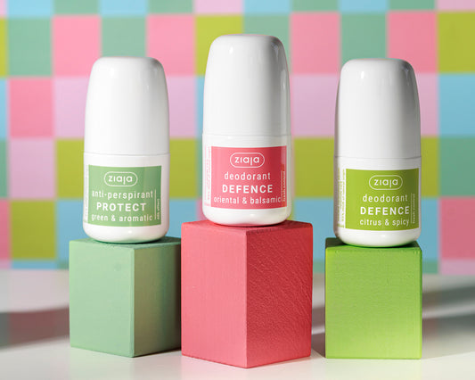 Three Ziaja deodorant bottles on colorful geometric blocks with a multicolored checkered background.