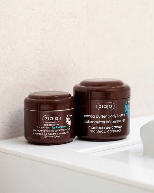 Two brown jars of Ziaja cocoa butter products, face cream light formula and body butter, placed on a white surface