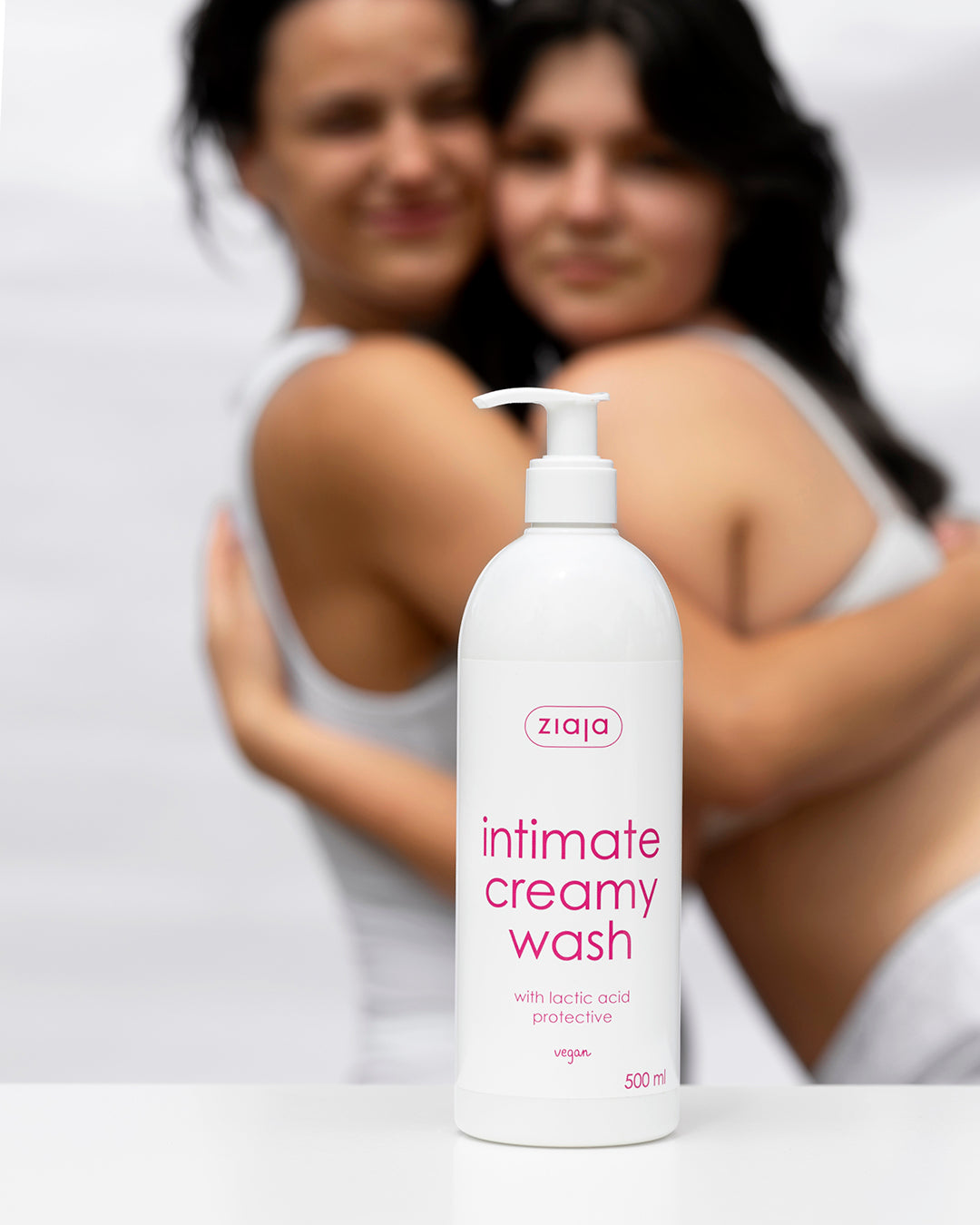 Ziaja intimate creamy wash bottle with two blurred women in the background