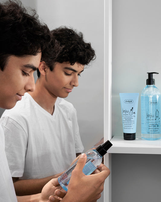A young men looking at Ziaja skincare products in a bathroom setting