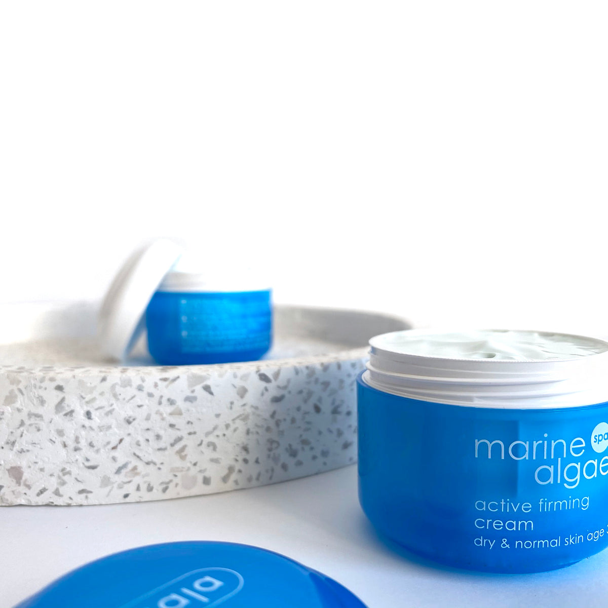Blue skincare jar labeled Ziaja marine algae' on a white background