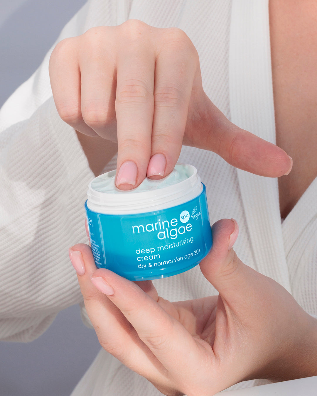 Person holding a jar of Ziaja marine algae deep moisturizing cream