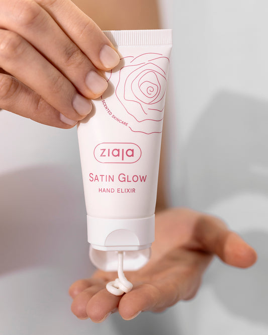 Hand holding a Ziaja Satin Glow Hand Elixir tube against a neutral background