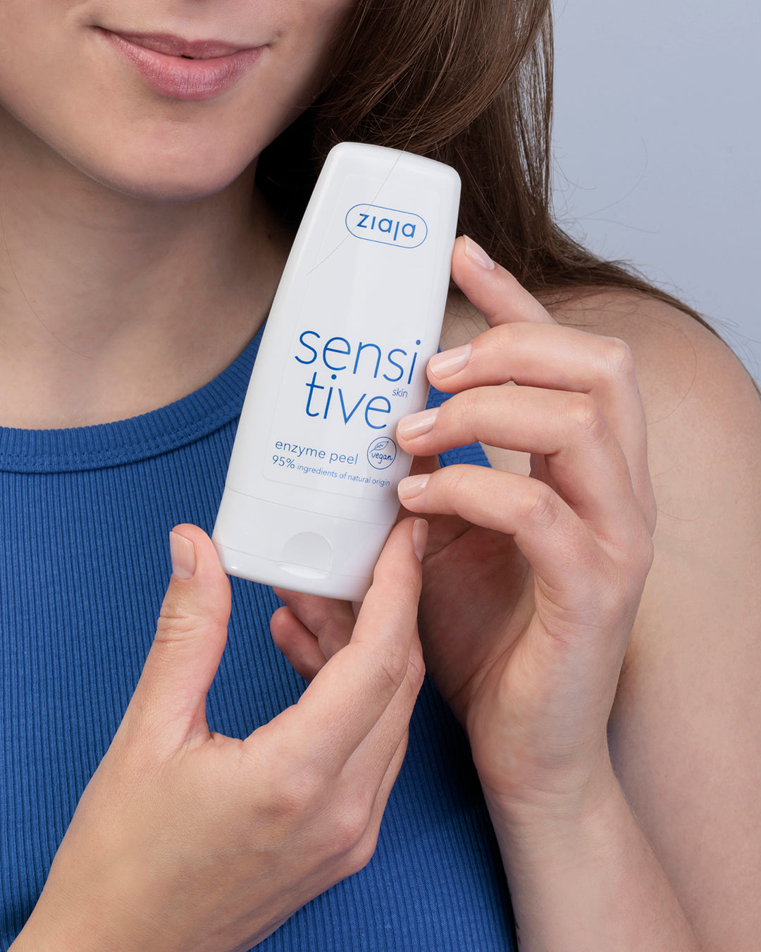 Person holding a Ziaja Sensitive Skin Enzyme Peel (vegan) tube on white background against a neutral background