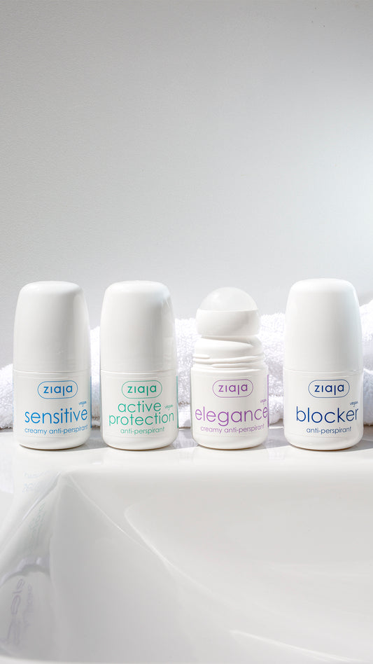 Four Ziaja anti-perspirants (Sensitive, Active Protection, Elegance, and Blocker) lined up on a bathroom surface with a white towel background.