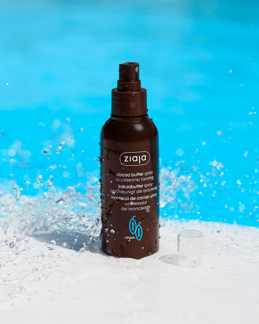 Ziaja cocoa butter spray bottle with a blue background