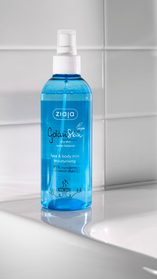 Ziaja face and body mist bottle on a bathroom counter with tiled wall background