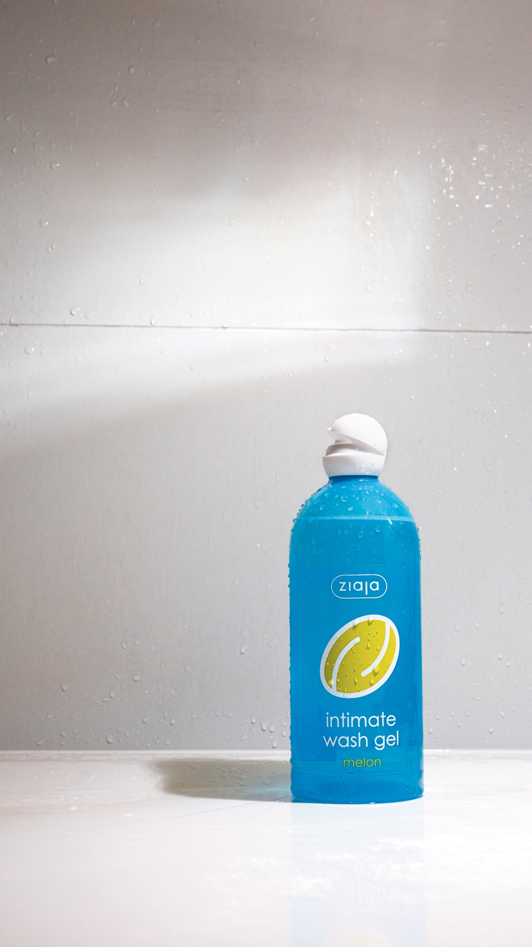 Blue bottle of Ziaja intimate wash gel on a white background