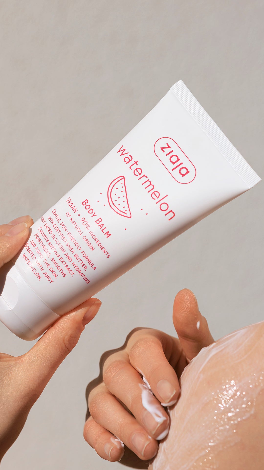 Hand holding a Zara watermelon body balm against a neutral background