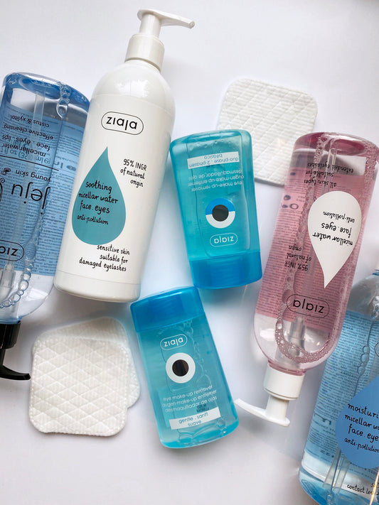 Flat lay of Ziaja Gentle Eye Make-Up Remover with Ziaja micellar water, cotton pads and other cleansing products on a white background.