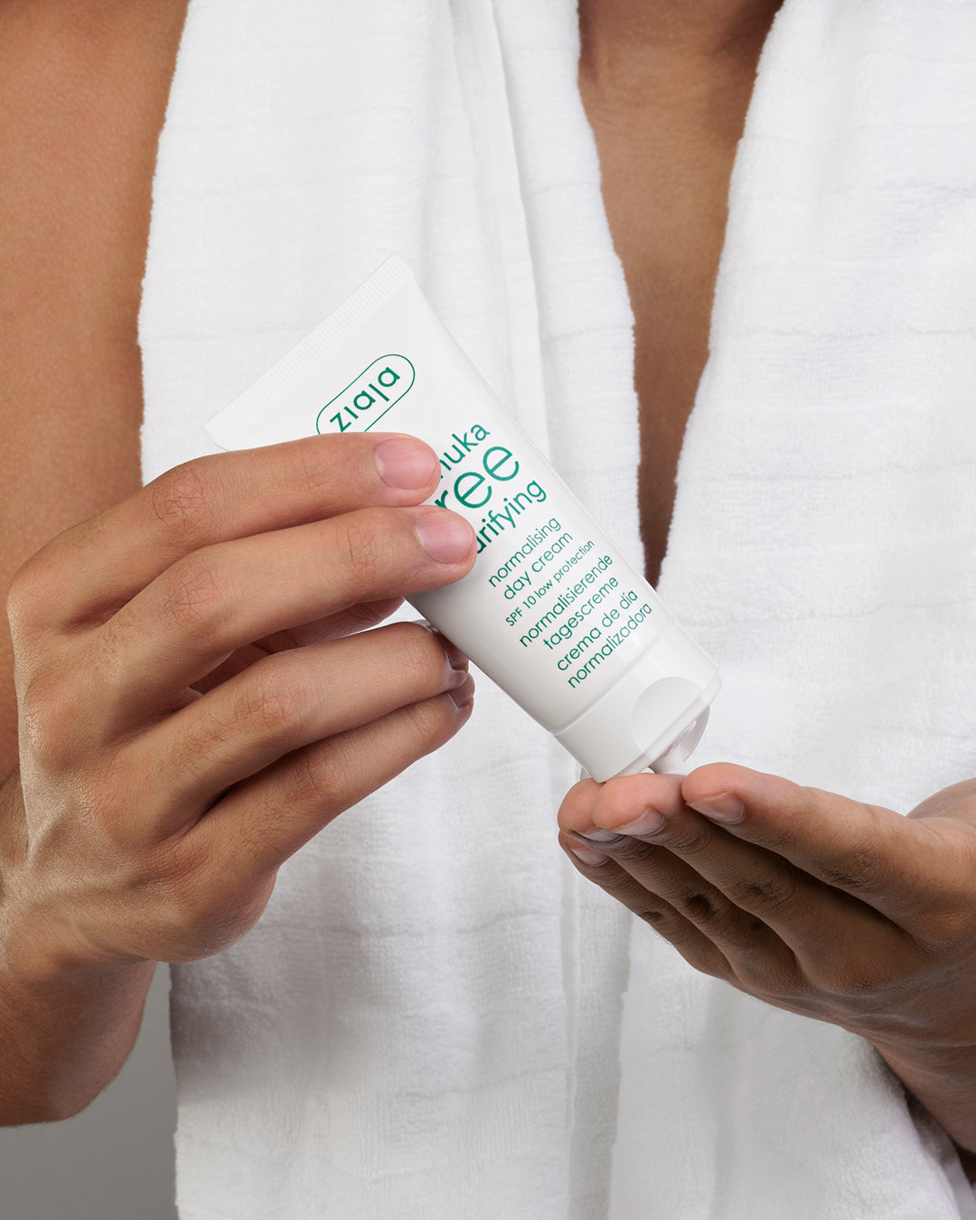 A tube of Ziaja Manuka Tree day cream in ands of a male model. 