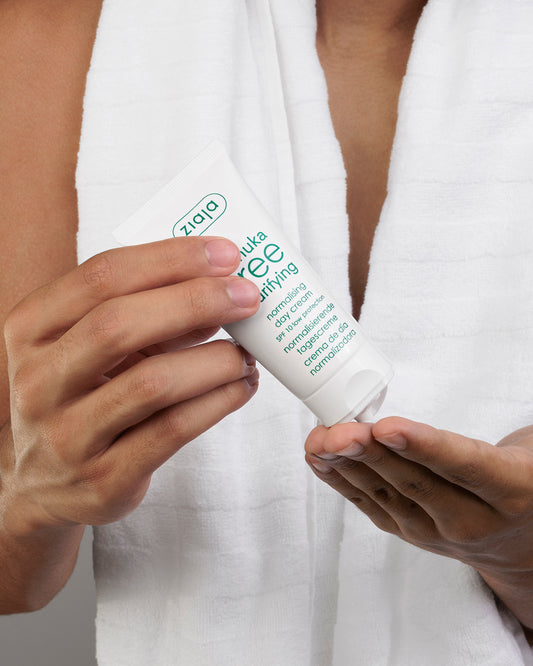 A tube of Ziaja Manuka Tree day cream in ands of a male model. 