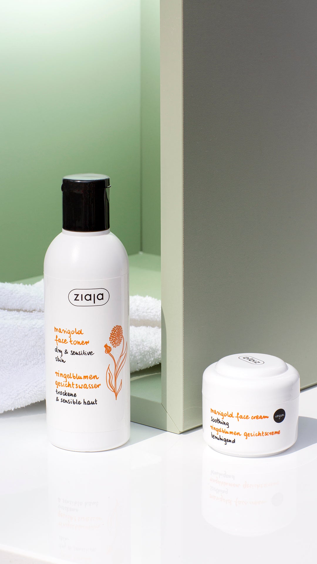 Two white skincare products from the brand Ziaja, including a facial toner bottle and a cream jar, styled on a white surface with a green background.