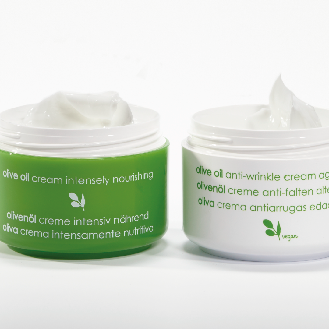 Two jars of Ziaja olive oil cream with green and white labels on a white background