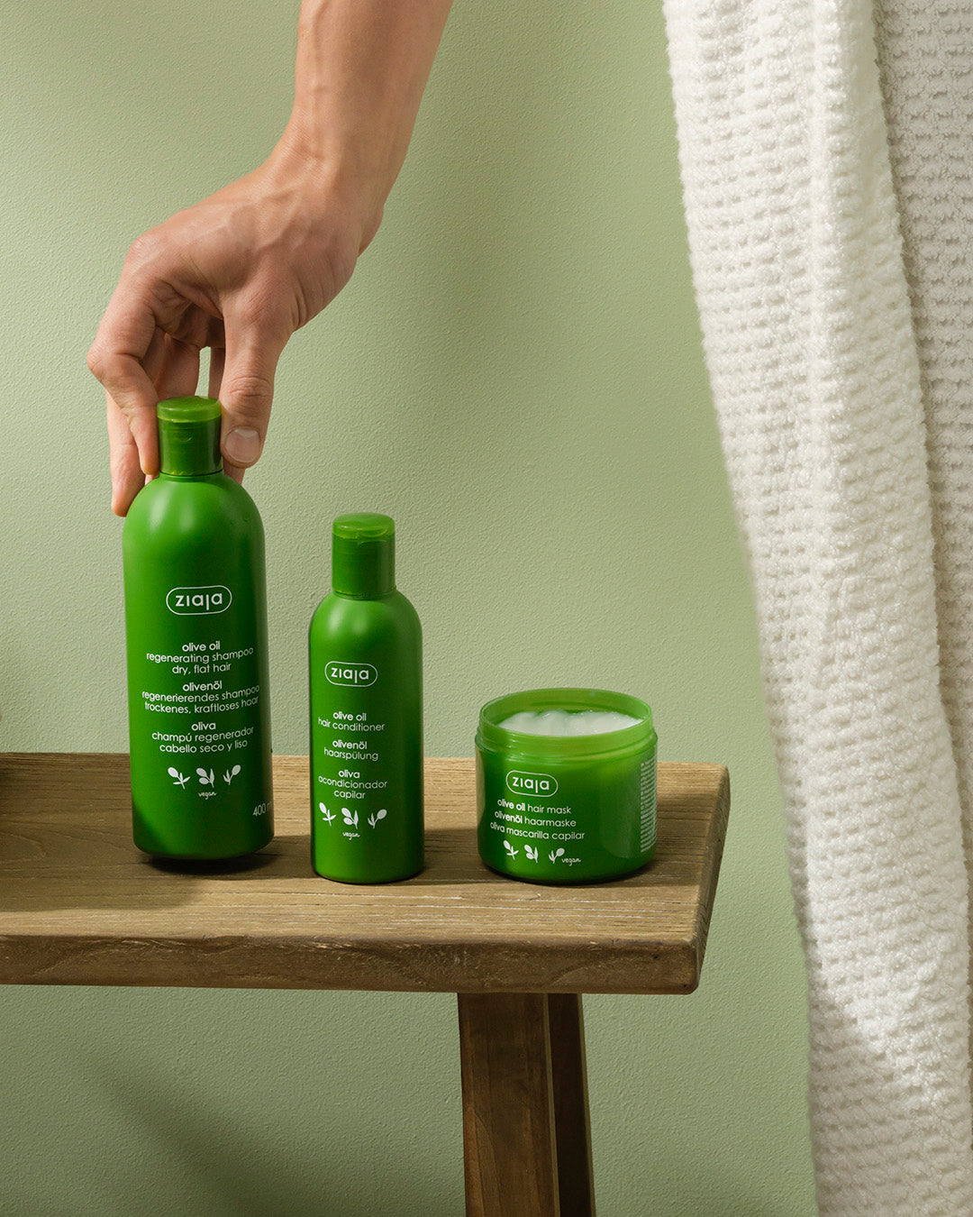 Ziaja skincare products on a wooden table with a green background
