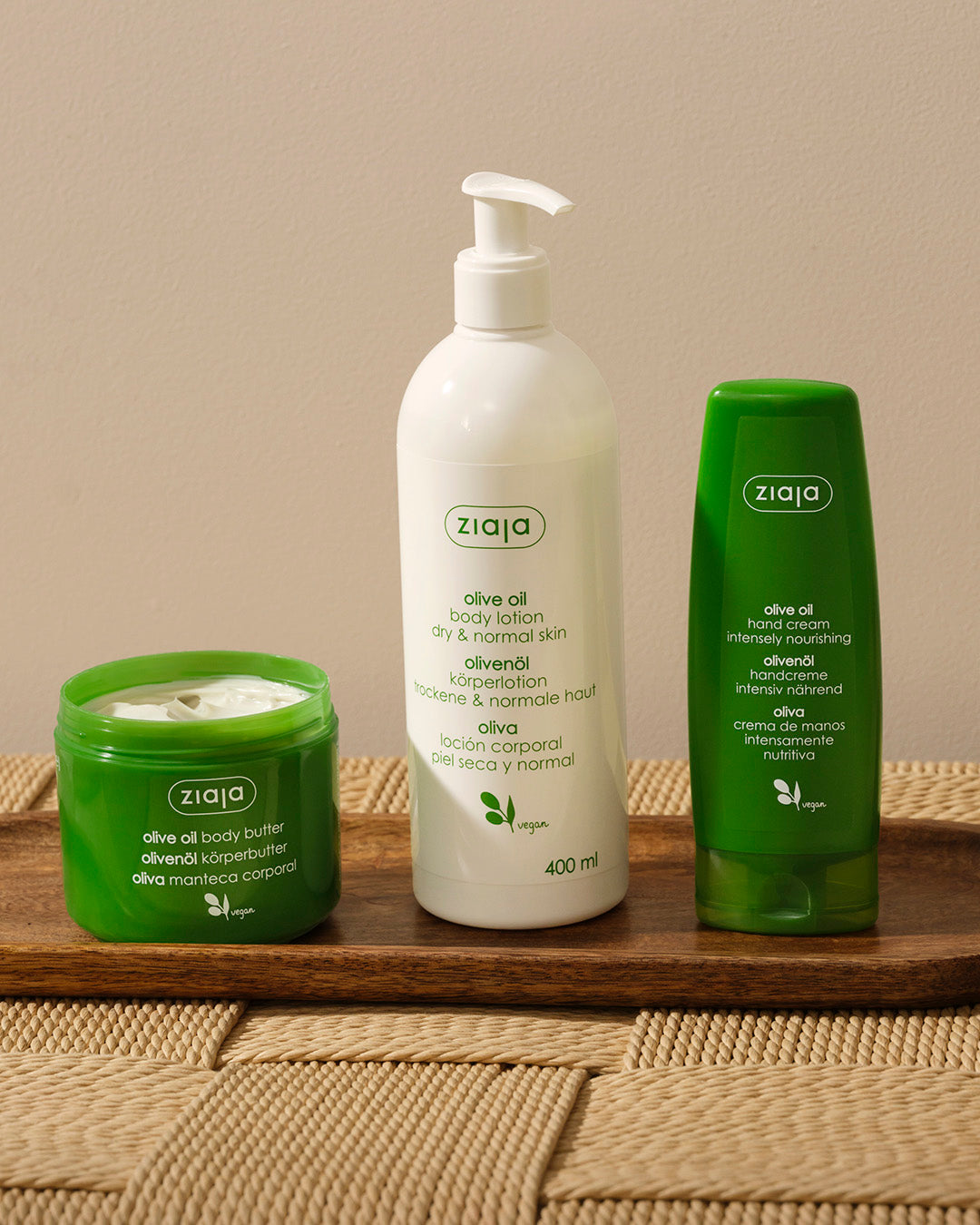 Ziaja olive oil skincare products on a wooden surface with a neutral background