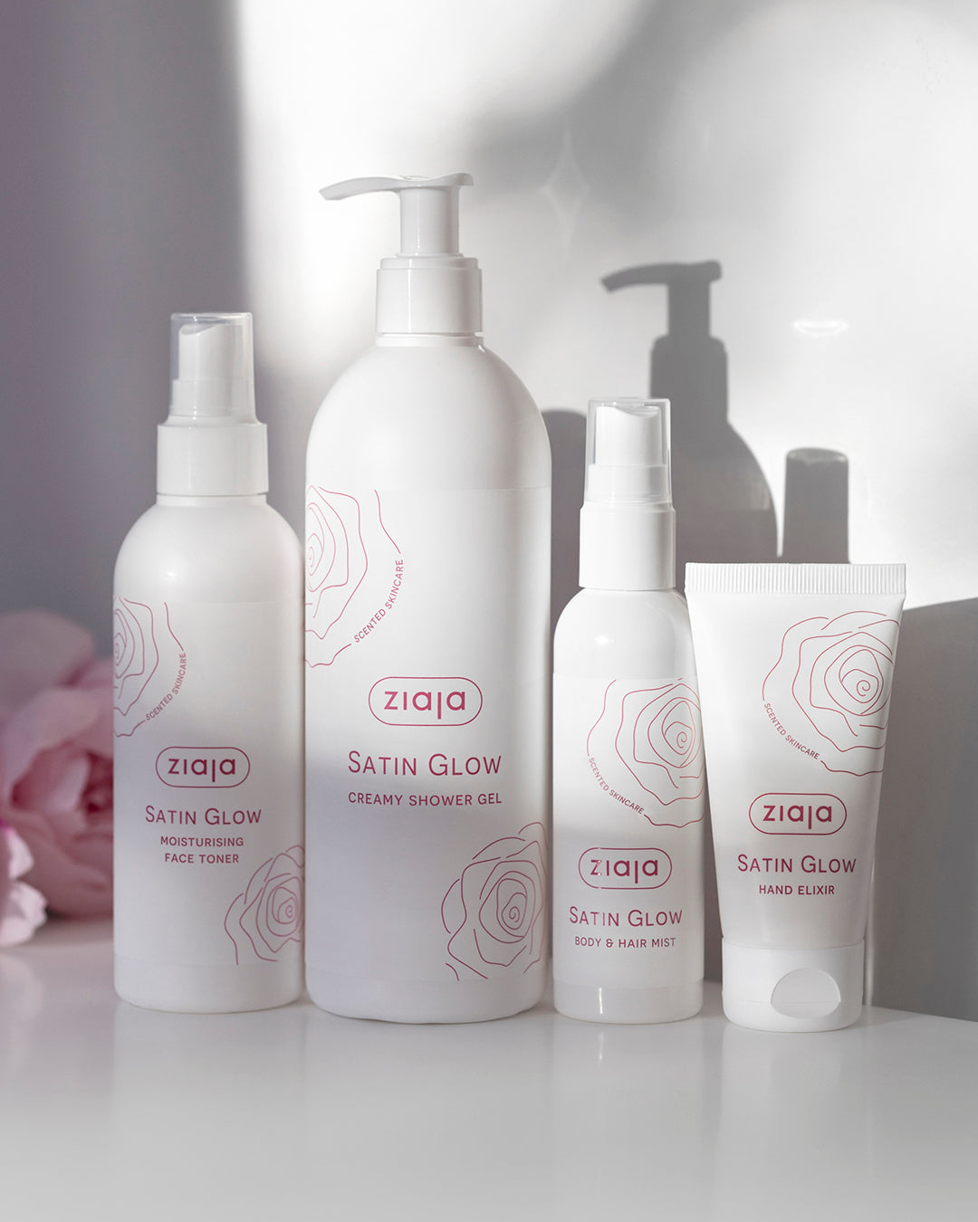 Ziaja Satin Glow skincare products on a white surface with a blurred background