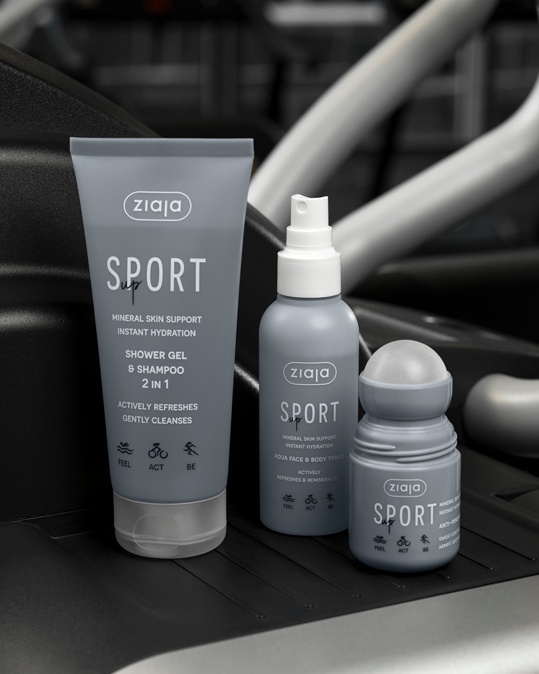 Ziaja Sport range products (2-in-1 shower gel & shampoo, aqua face and body toner spray, and anti-perspirant roll-on) on a gym equipment background.