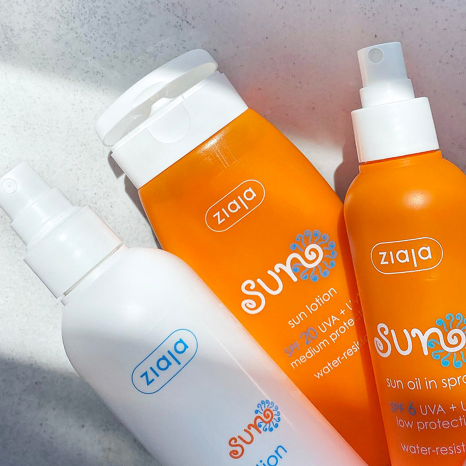 Ziaja Sun products close-up on a grey background – SPF 20 sun lotion, SPF 6 sun oil spray and sun lotion bottle