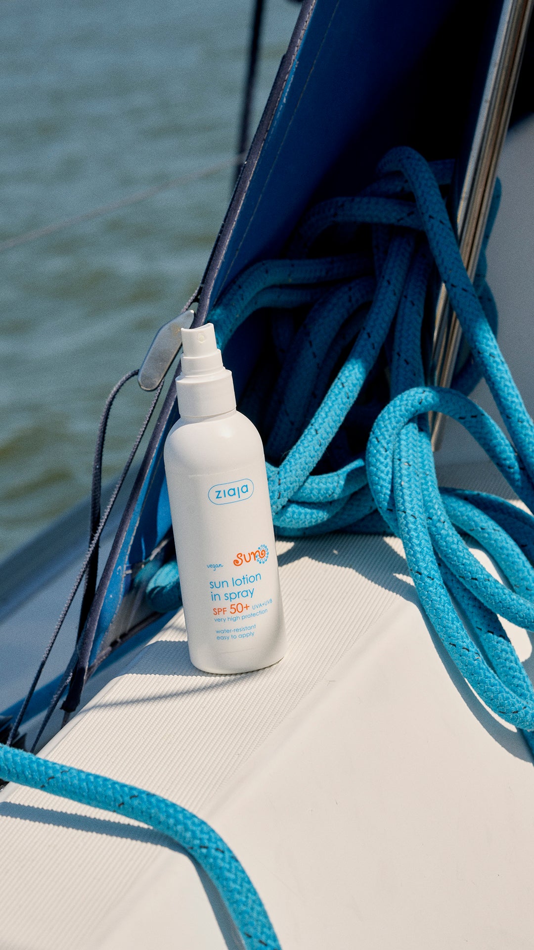 Ziaja Sun Moisturising Body Lotion In Spray Spf 50+ 170 Ml sunscreen spray bottle on a sailboat with ropes and water in the background