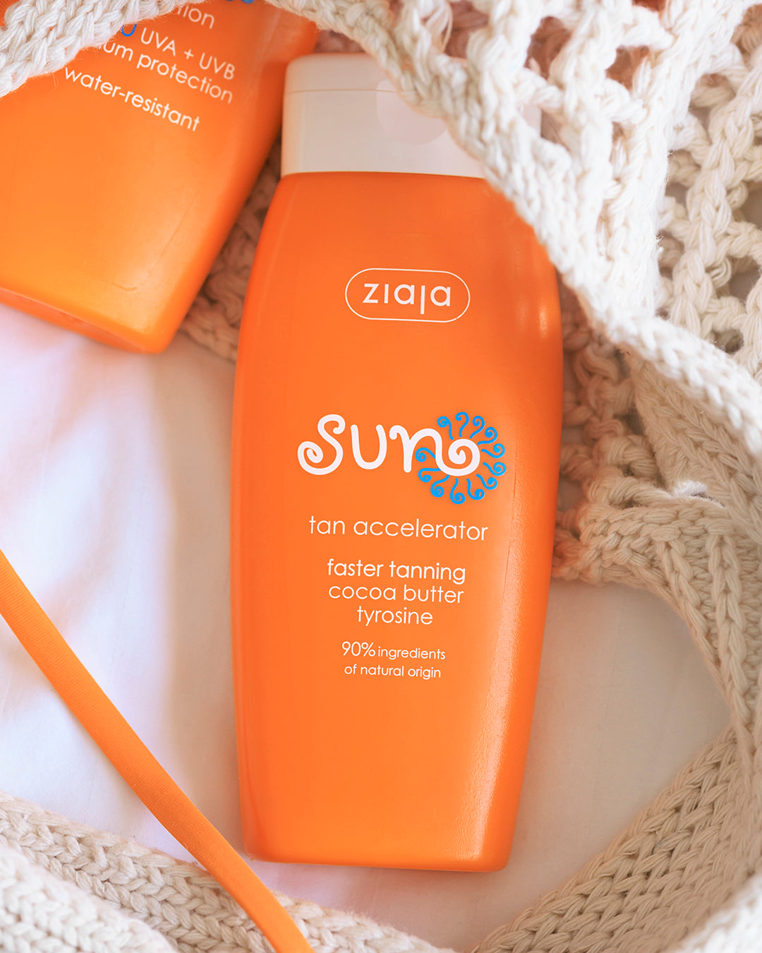 Ziaja Sun Tan Accelerator bottle in a knit beach bag, flat lay product photo
