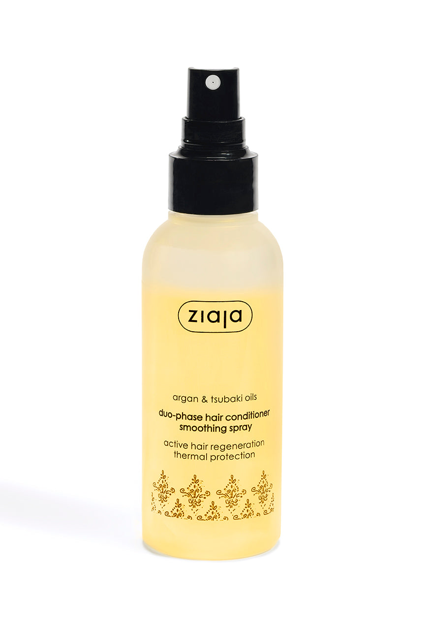 A spray bottle of Ziaja Argan & Tsubaki Oils Duophase Hair Conditioner Smoothing Spray with a black spray nozzle on a white background.